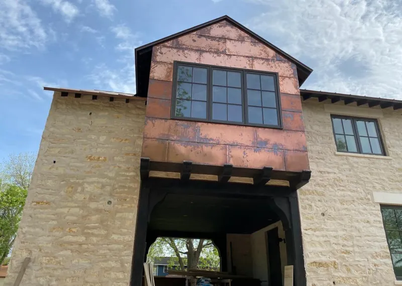 Copper metal panel facade on a stone building for Skylight Installation in Whispering Pines