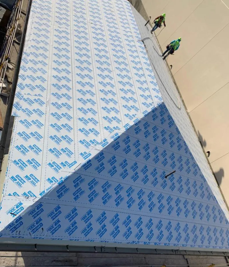 Professional roofers installing underlayment on a metal roof in Whispering Pines